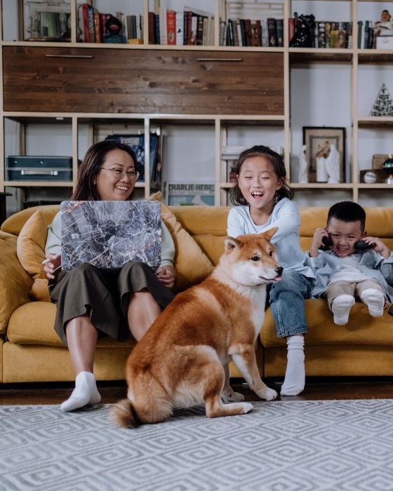 chien assis sur le tapis et famille sur le canapé